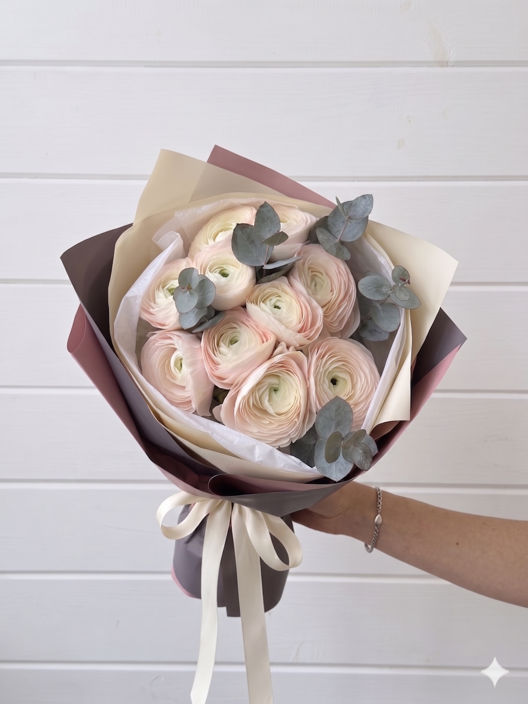 Bouquet of light pink ranunculus flowers with greenery in paper wrap in chicago