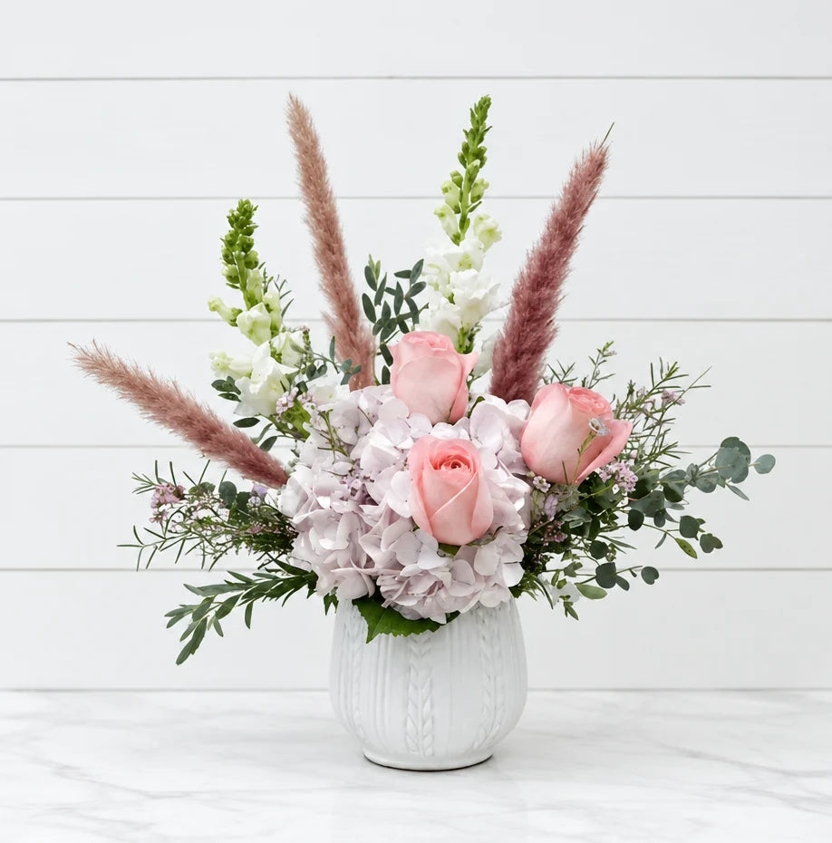 Vase arrangement on a window sill at dusk, ordered online any hour with same day flower delivery in Chicago