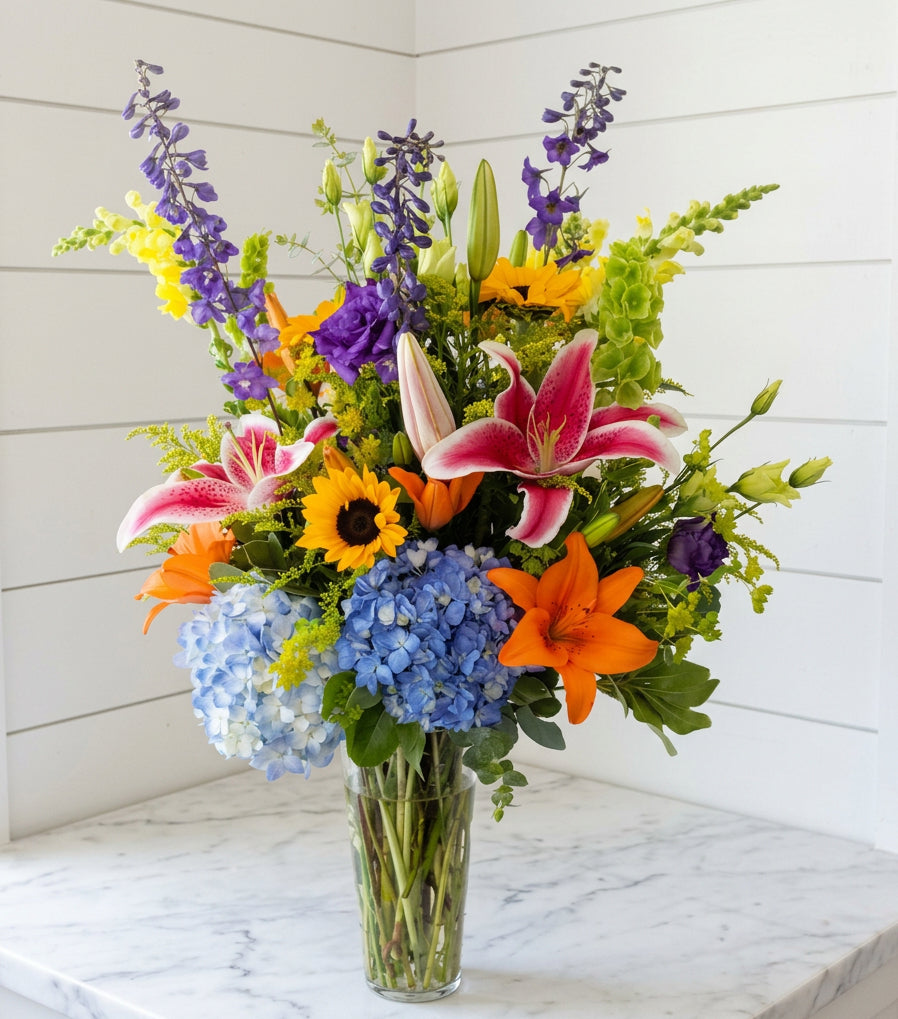 Colorful floral mix in clear tall vase