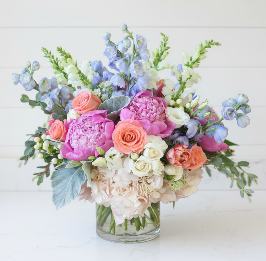 Colorful peonies flower arrangement in a glass vase on a white background